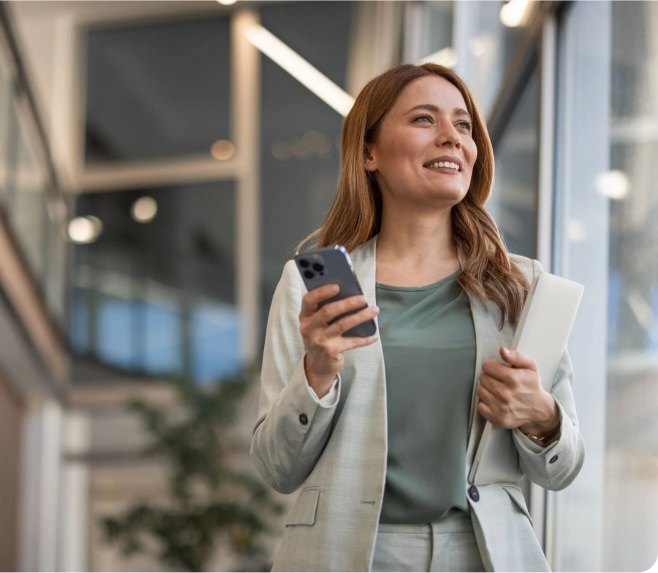 Business woman holding phone and notebook walking in office-1