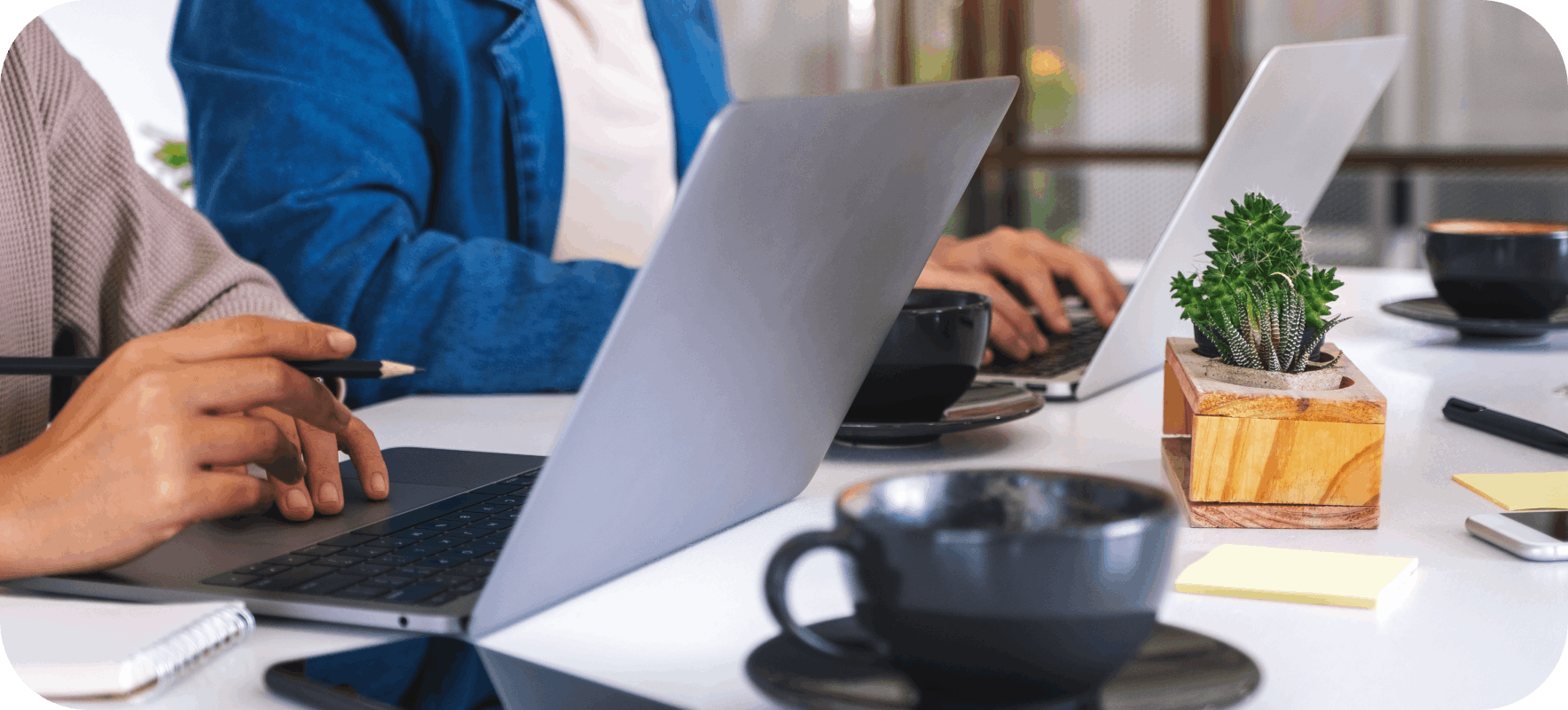 Two people using laptops on a desk